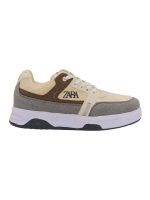 کفش کتونی ونس زارا طرح ZARA کرم قهوه ایI will provide 3 images of a sneaker from different angles. Using these images, generate a photorealistic render of a model wearing the exact same sneaker, making the sneaker the focal point of the scene. Requirements: Recreate the sneaker exactly as shown in the images (color, texture, patterns, sole design), ensuring the details are highly visible and clear. Place the shoes naturally on the model’s feet with correct perspective and realistic foot shape, emphasizing the sneakers. Adjust the lighting and shadows to highlight the shoes, making them stand out in the scene. The focus should be on making the sneakers the primary visual element. Model Styling: Choose the best outfit that complements the sneaker, but the outfit should not distract from the shoes. If the sneaker is sporty → style should be sporty/streetwear, but with a focus on showcasing the sneakers. If the sneaker is neutral/minimal → style should be clean and minimal, with less emphasis on the outfit. Colors of the outfit should harmonize with the sneaker, but the model’s posture and pose should direct attention to the shoes. Location: The model should be placed in an urban environment, such as a city street, alley, or an industrial background. Make sure the environment feels dynamic but not overpowering, with some elements like street art, buildings, or subtle architectural features. The lighting should be adapted to an outdoor setting (daylight, soft shadows, etc.) to blend the sneakers naturally with the urban backdrop. Pose and Angle: The model should be posed in a way that the sneakers are clearly visible and accentuated (e.g., standing on a street corner, walking along a sidewalk, or posing against a graffiti wall). Full-body model in an urban location with soft, natural lighting that focuses on the shoes. Output: High-quality, full-body model with the sneakers prominently visible, set against a stylish urban backdrop, perfect for online shops or advertising. The render should look like a natural, commercial-grade product-on-foot visualization with the sneakers as the center of attention, seamlessly integrated into the city environment.